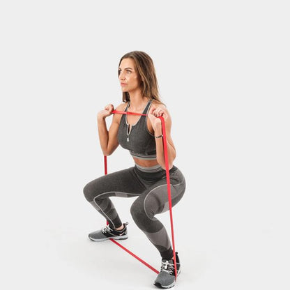 femme exercice squat avec élastique musculation 