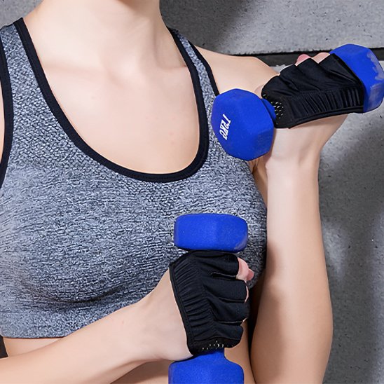 femme souléeve haltères avec gants pour la musculation